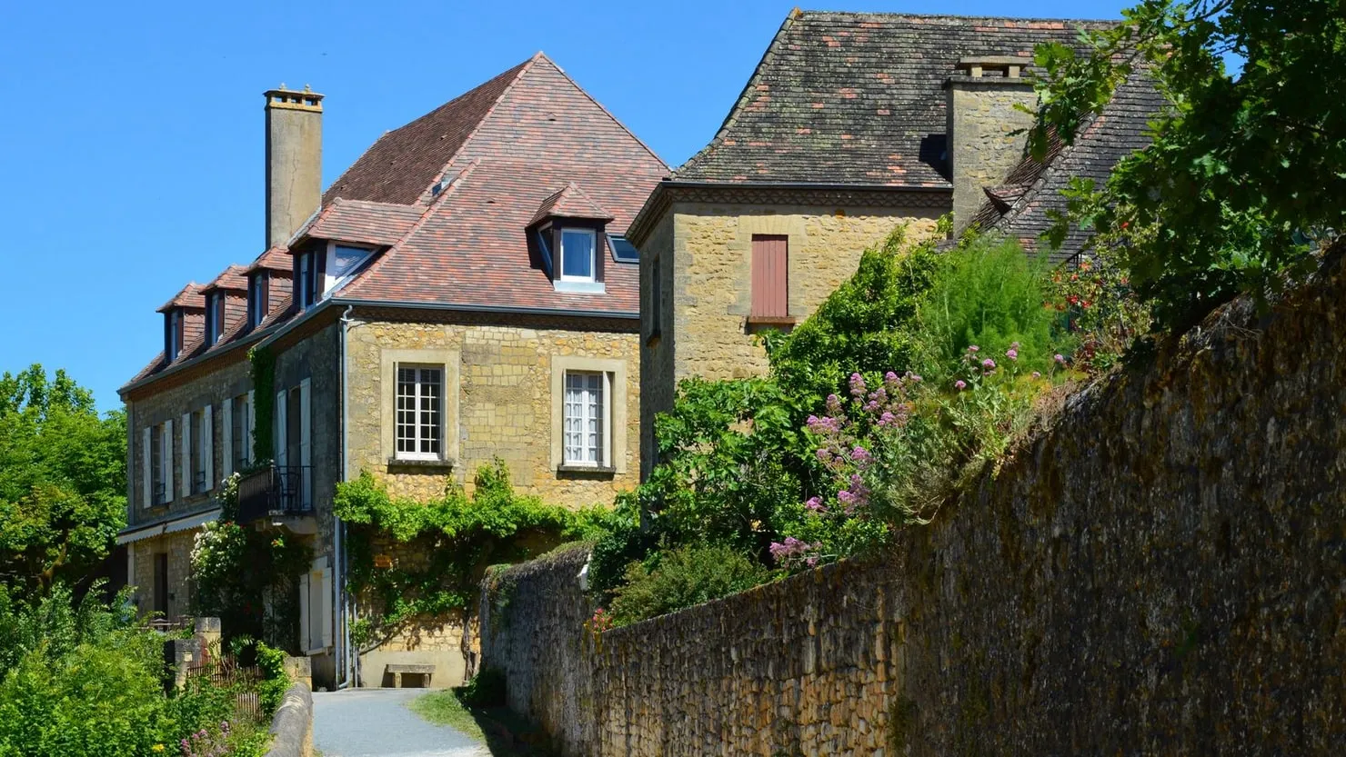 Maisons en pierre typiques de Dordogne entourées de verdure